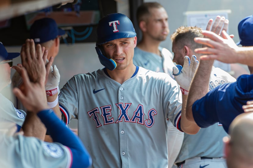 Texas Rangers' Corey Seager celebrates with teammates after hitting a solo home run off...