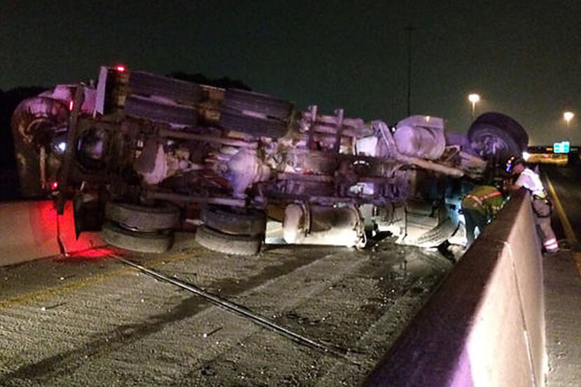 An overturned concrete truck blocks the HOV lane of eastbound Interstate 30 Wednesday...