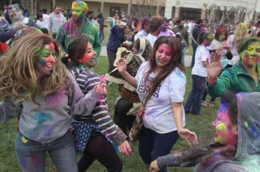 
Revelers covered in colored powder danced to Indian music during this year’s Holi...
