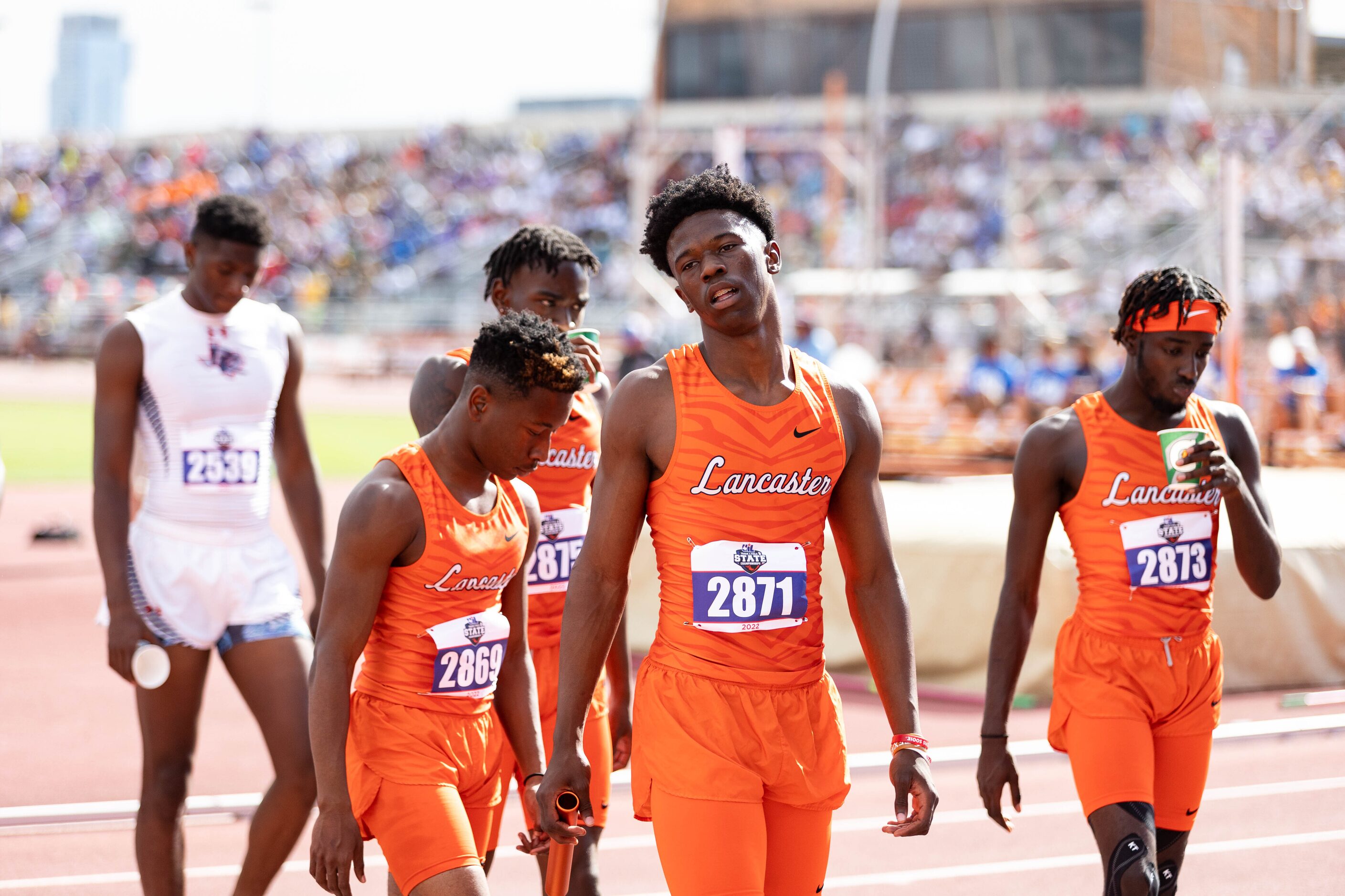 Corian Gipson of Lancaster, center, walks off the track after finishing third in the boys’...