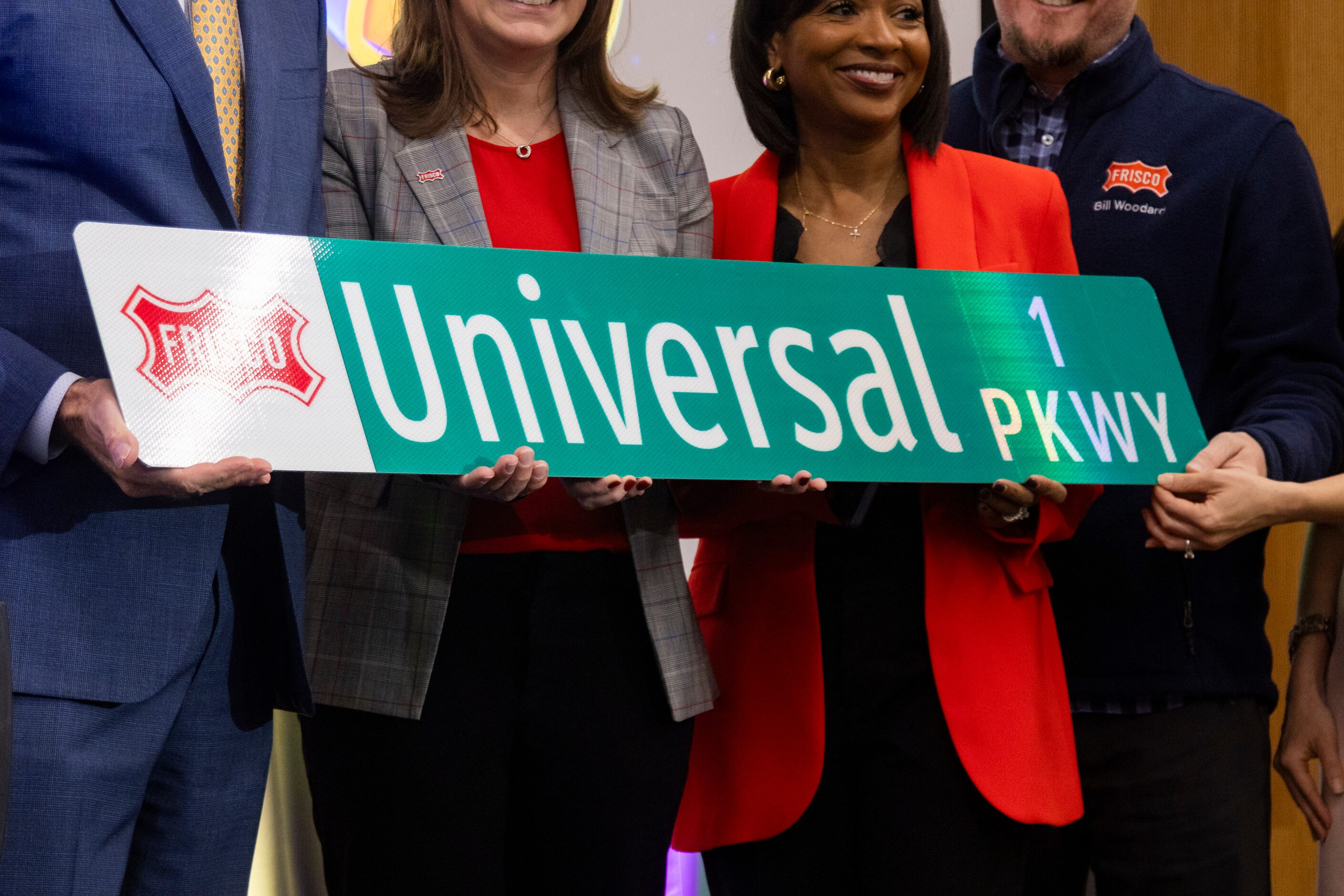 Frisco council members hold a Universal Parkway street sign following the introduction of...