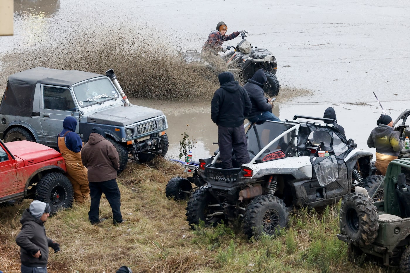 A person on an ATV sprays water as they do donuts in an empty lot near downtown Dallas,...