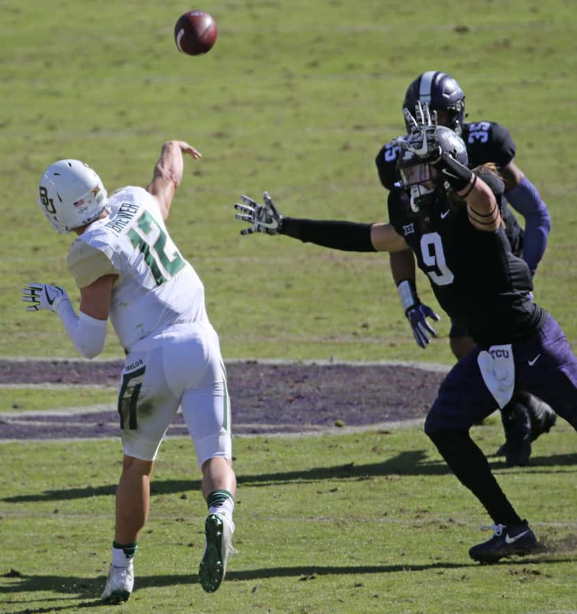 Baylor Bears quarterback Charlie Brewer (12) throws under pressure from  TCU Horned Frogs...