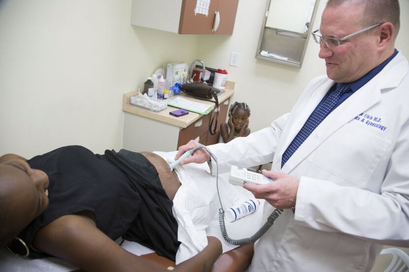 Tyriesha Williams of Hollywood, Fla., is examined by her obstetrician, Dr. Aaron Elkin, as...