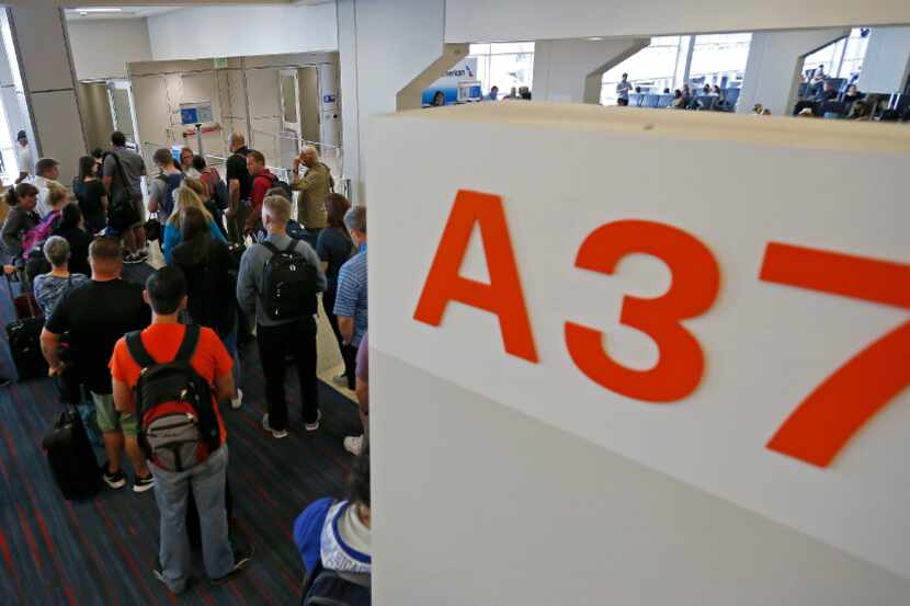 Passengers line up to board a flight in Terminal A at DFW International Airport.