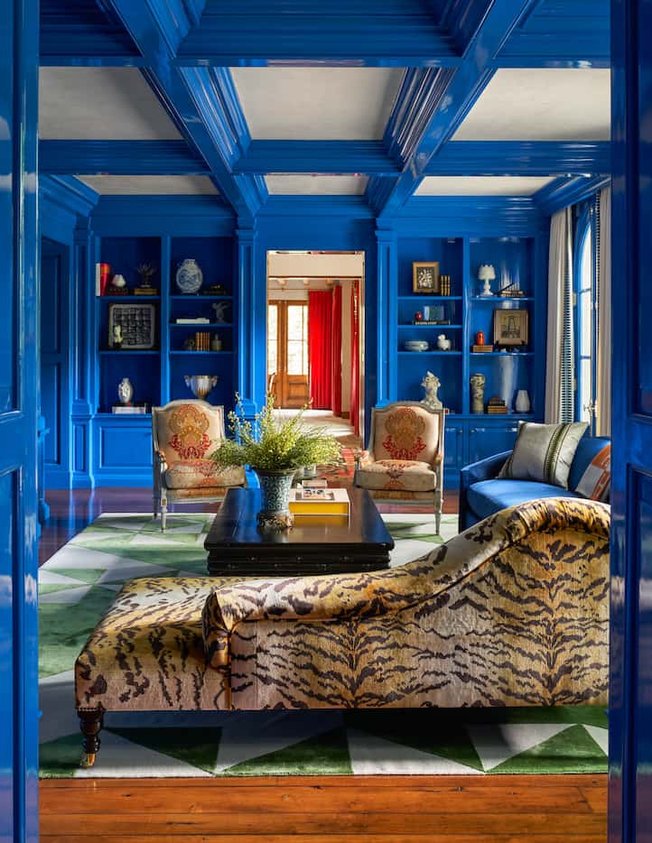 Bright blue lacquer serves as a backdrop for this study's unique seating and rug.