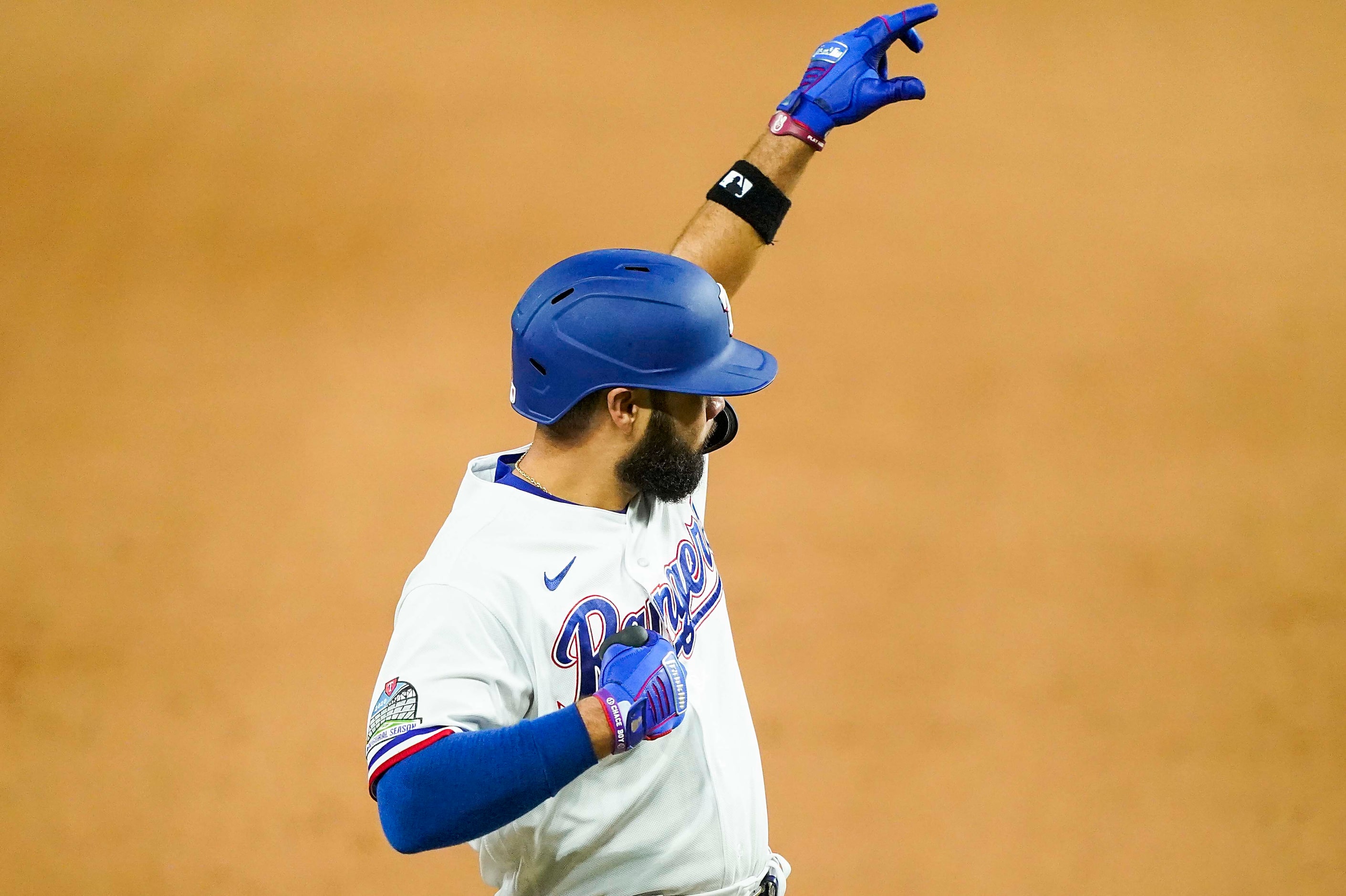 Texas Rangers infielder Isiah Kiner-Falefa celebrates at third base after hitting the first...