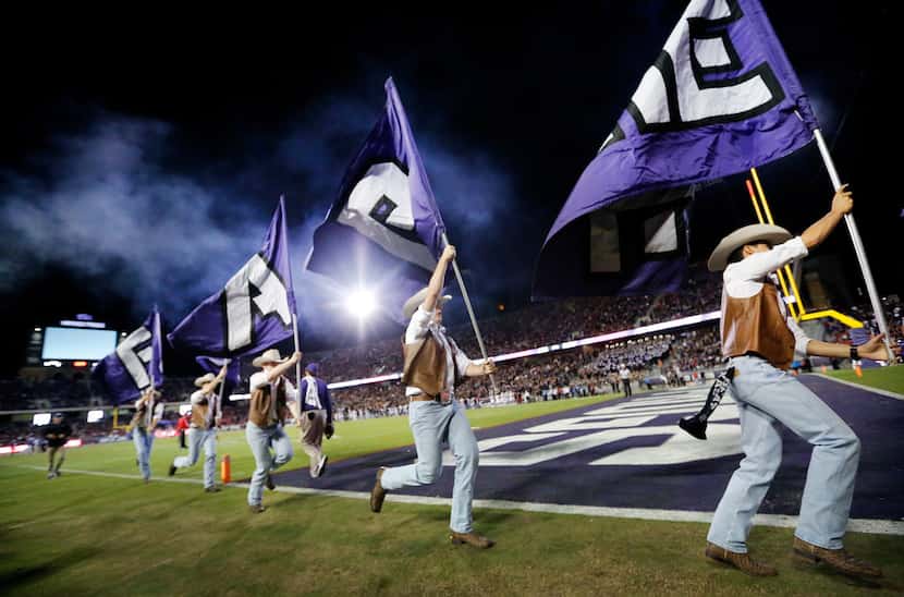 TCU Rangers spirit members race down the field with flags after they scored on the Texas...