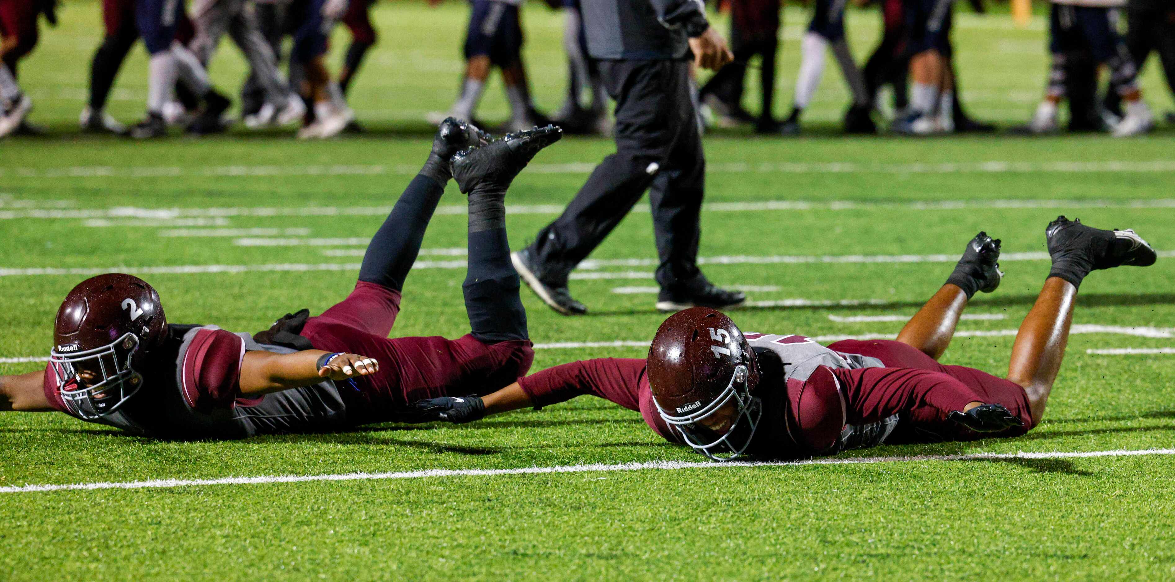 Mansfield Timberview linebacker Joel Ardern (2) and wide receiver Titus Evans (15) slide on...