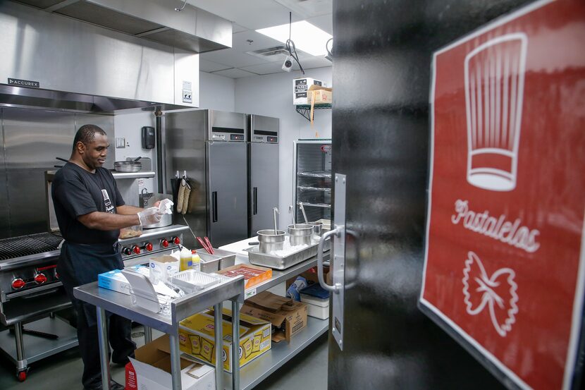 Roger Sackey, owner of Pastalelos, puts on a pair of plastic gloves to prepare a serving of...