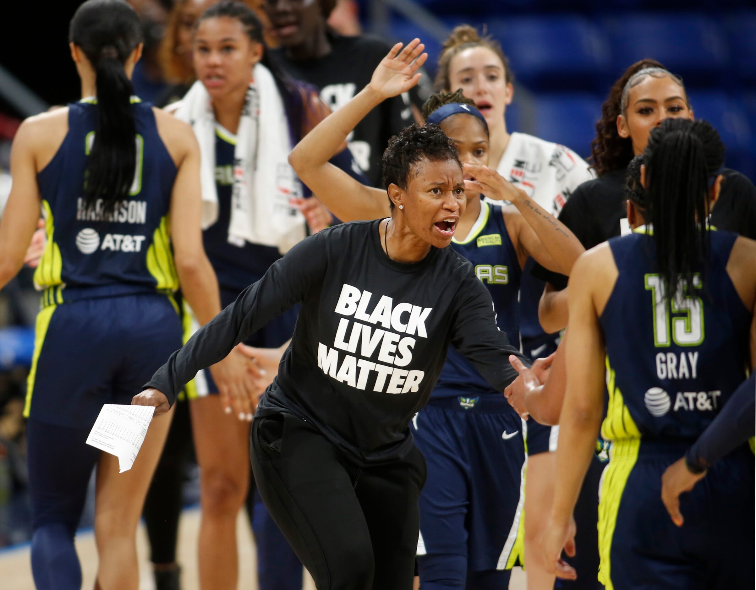 Dallas Wings head coach Vickie Johnson enthusiastically greets her players as they head to...