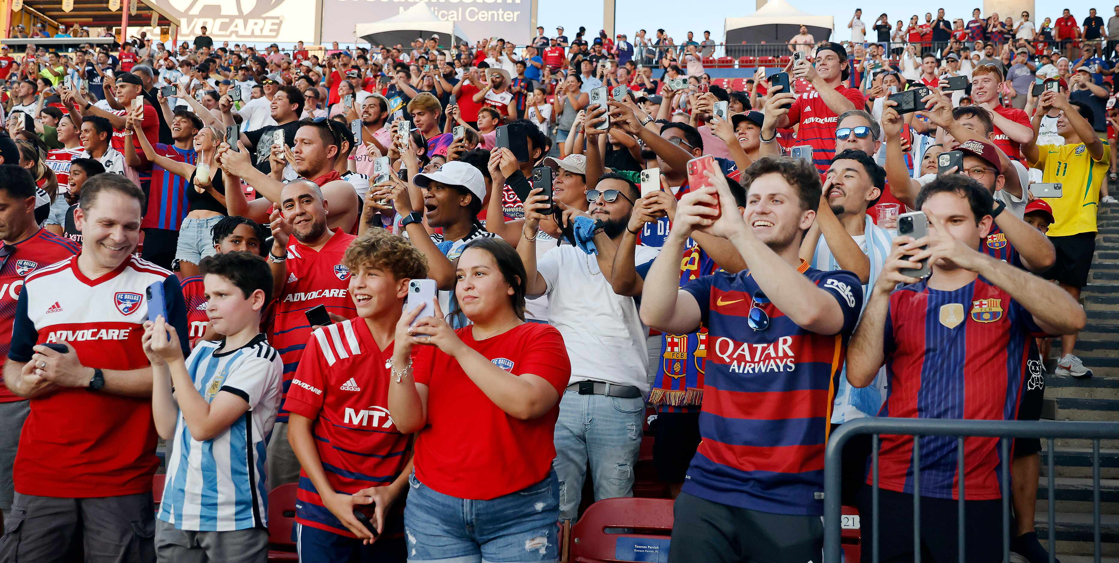 Fans of Inter Miami’s Lionel Messi cheer and record for him as he takes the pitch for...