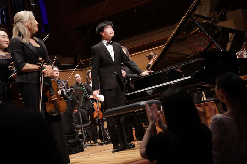 Pianist Yifan Wu acknowledges applause following his performance with conductor Valentina...