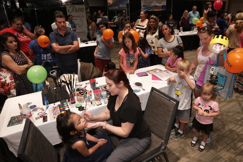 Community members visit various activity booths during a health fair hosted by the Holistic...