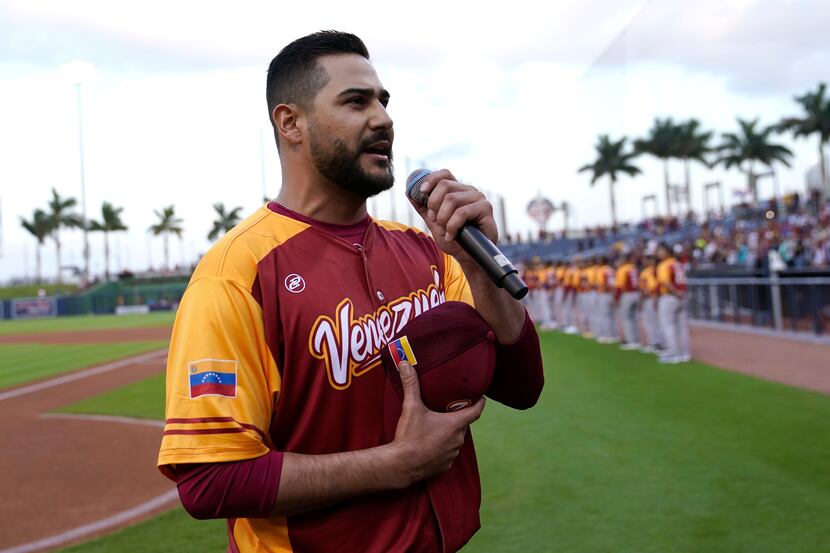 Venezuela's pitcher Martin Perez sings the Venezuelan national anthem before an exhibition...