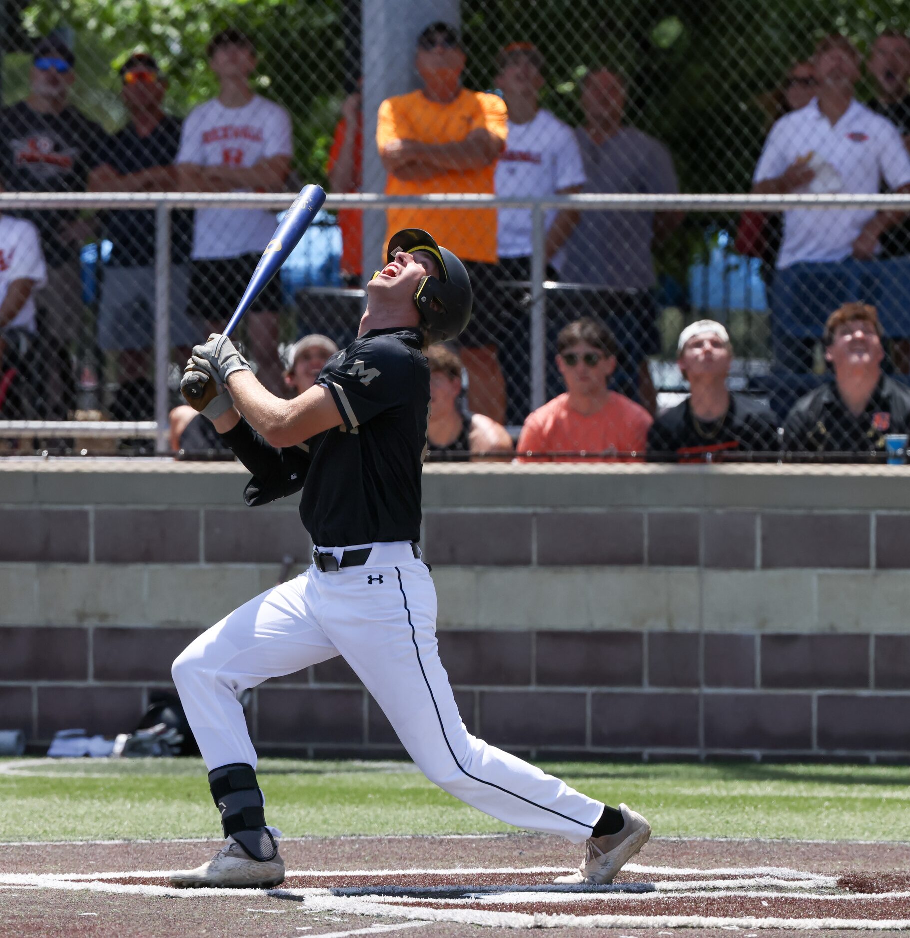 Mansfield right fielder Braxton Van Cleave (10) turns his head to follow his hit flying...