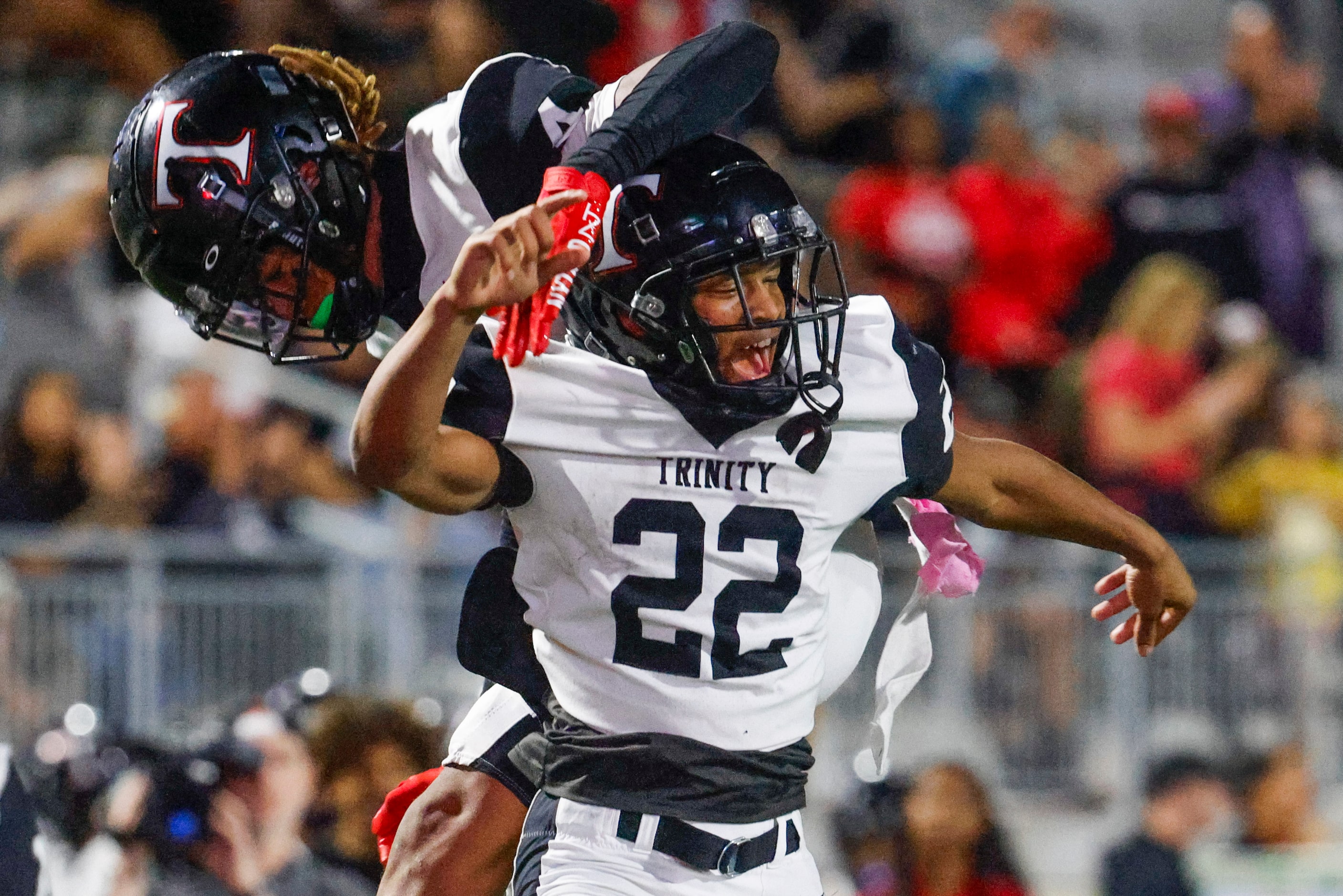 Trinity High’s JT Harris (22) and Jarvis Heimuli celebrate a touchdown by Harris against...