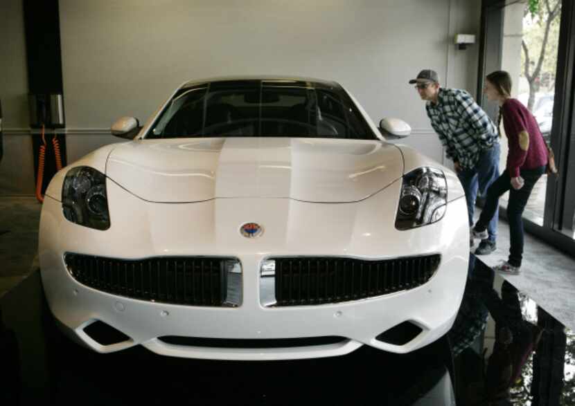 Don Wood and his daughter look at the Fisker Karma electric car on display in Highland Park...