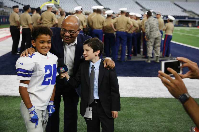 Broadcaster Mike Tirico (center) greets Grayson Shaw (left), 8, of Denton, Texas, who is...