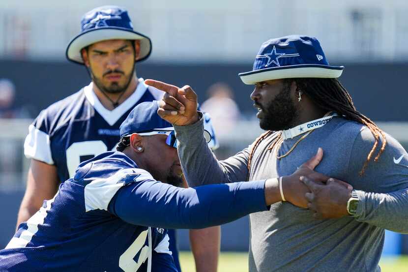 Dallas Cowboys defensive end Chauncey Golston (99) works with assistant defensive line coach...
