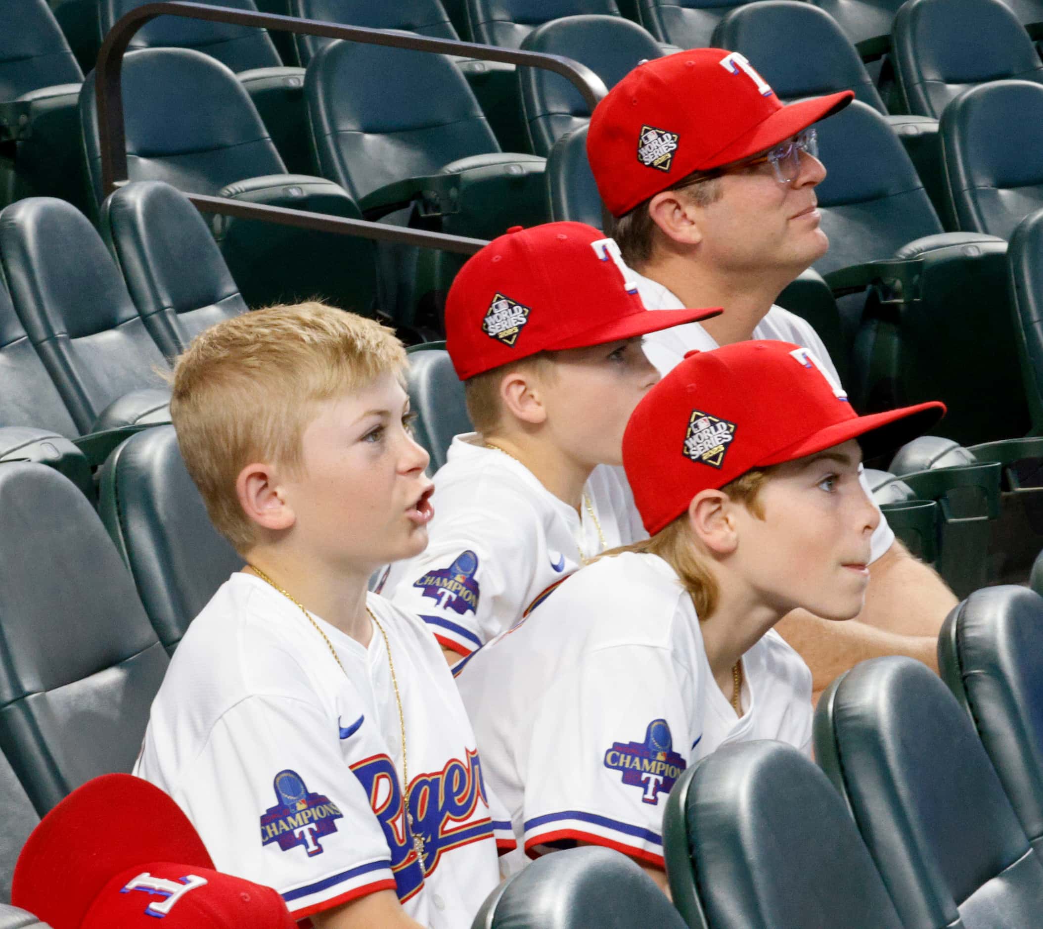 Texas Rangers fans Josiah Dillon, 9, of Colleyville, Texas, from left, his twin brothers Ben...