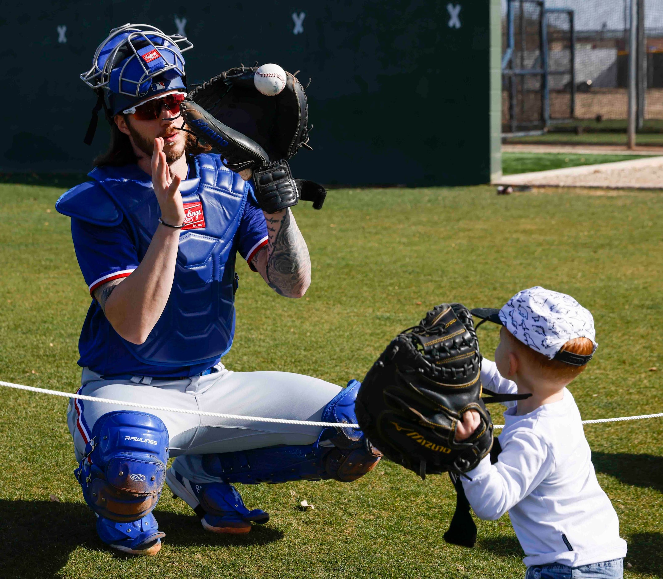 Texas Rangers catcher Jonah Heim catches a ball while playing with his son Mash, 2, before a...