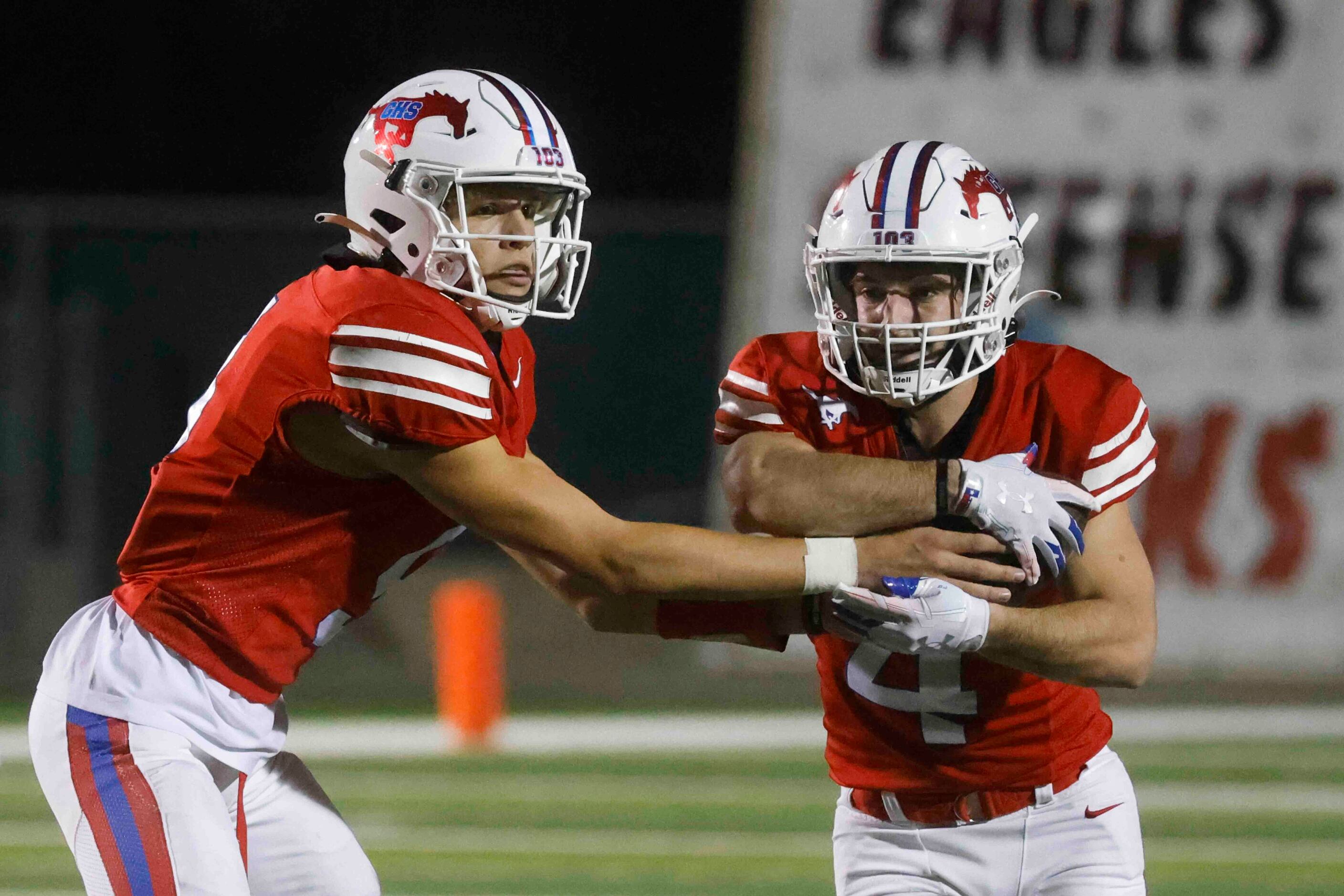 Grapevine High’s QB Evan Baum (9), left, gives the ball to Parker Polk (4) during the first...