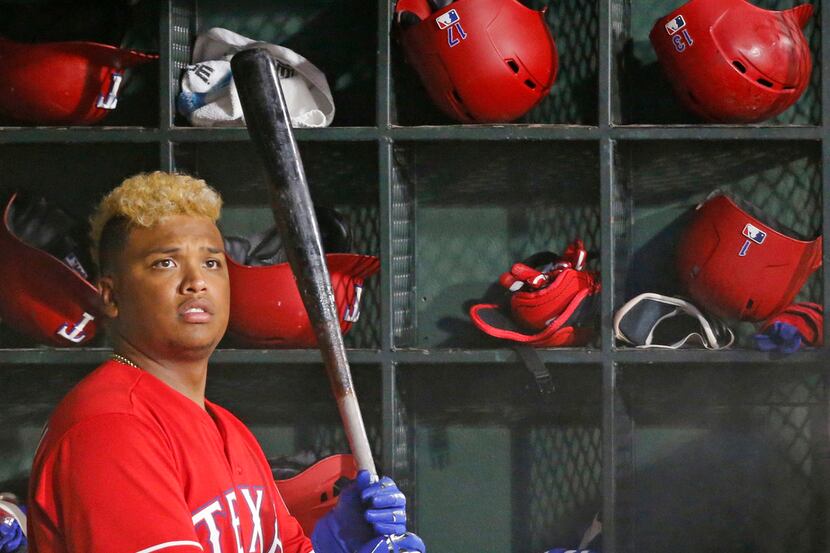 Texas Rangers designated hitter Willie Calhoun (5) waits for an at bat in the dugout in the...