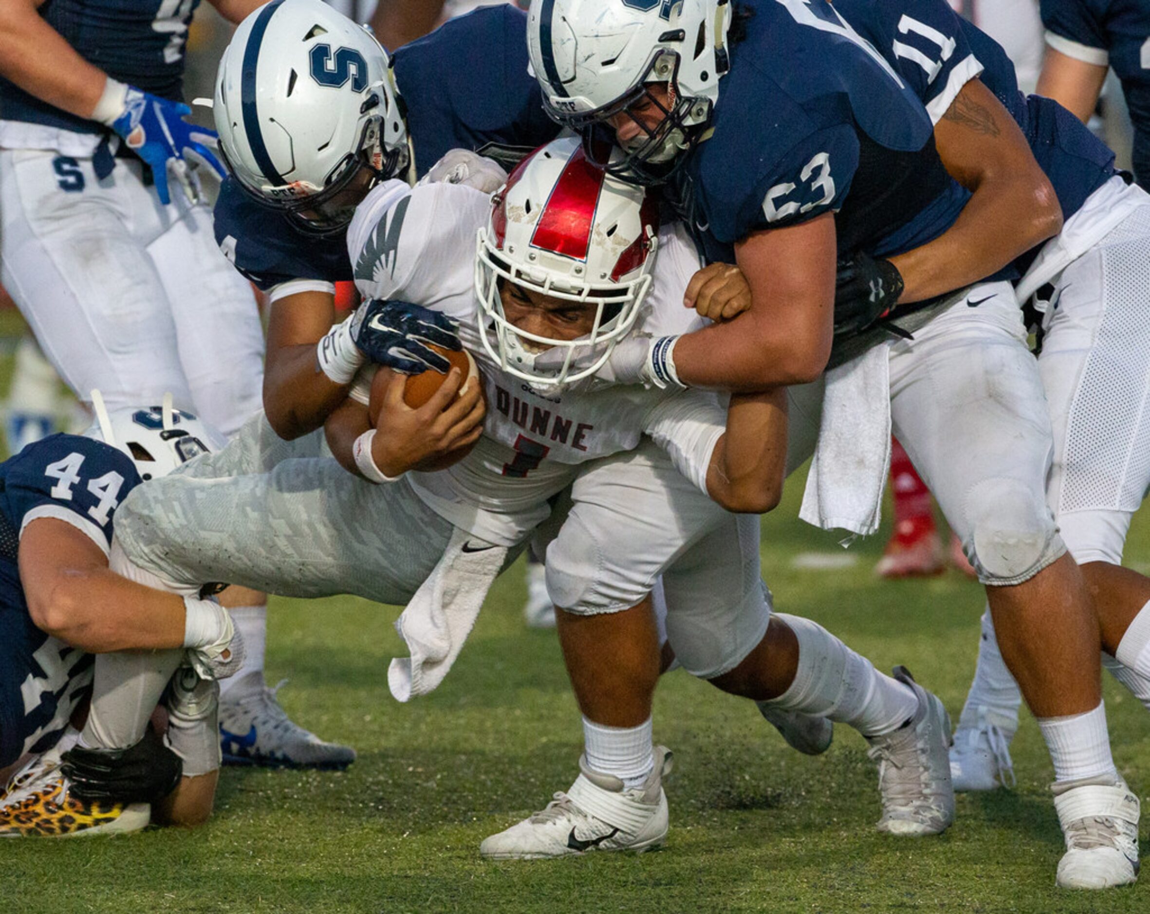 Bishop Dunne quarterback Simeon Evans (1) gets taken down by All Saints' Episcopal defensive...