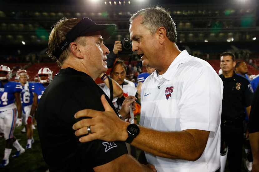 SMU head coach Sonny Dykes, right, and TCU head coach Gary Patterson, left, shake hands...