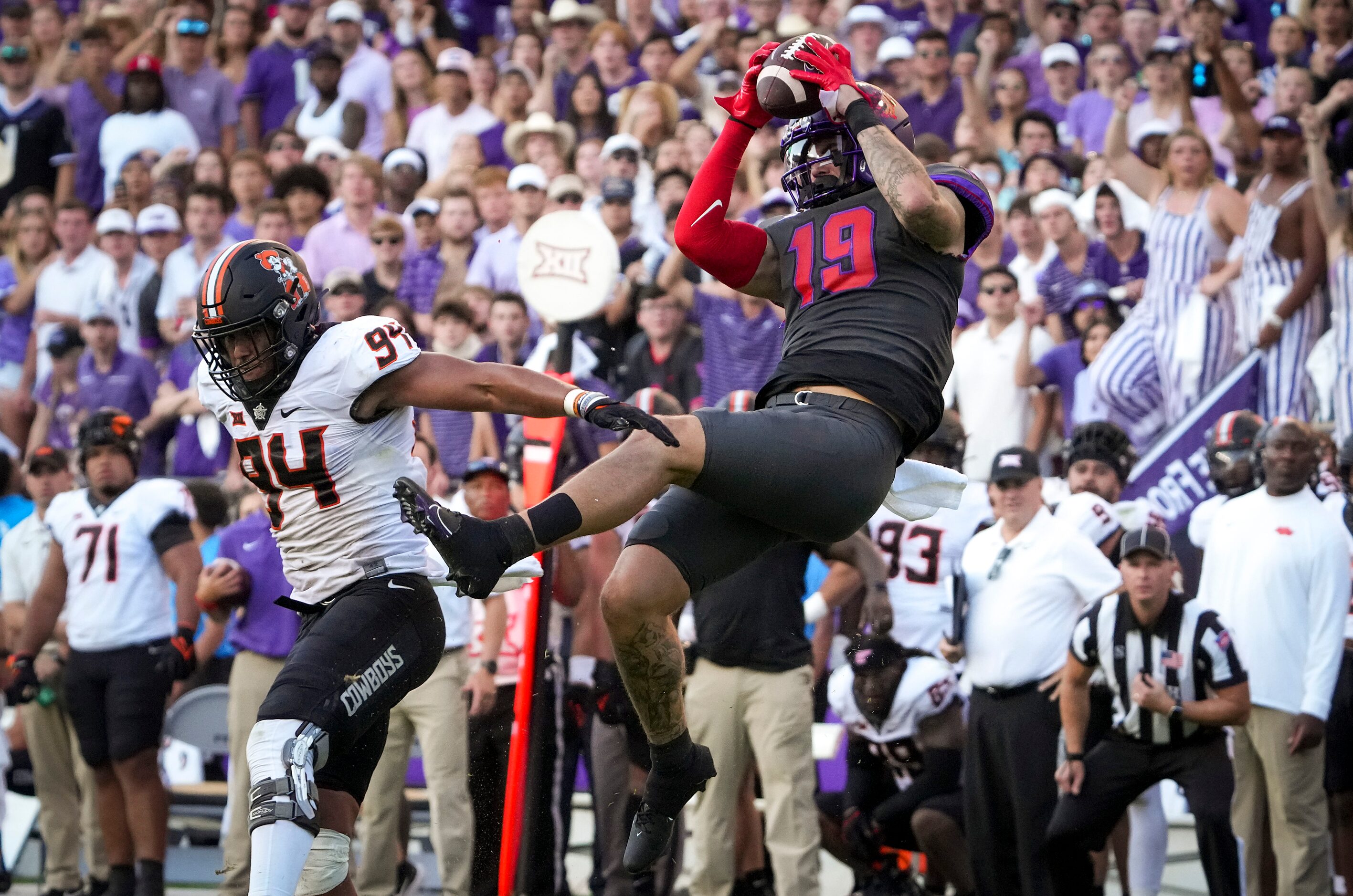 TCU tight end Jared Wiley (19) makes a catch over Oklahoma State defensive end Trace Ford...