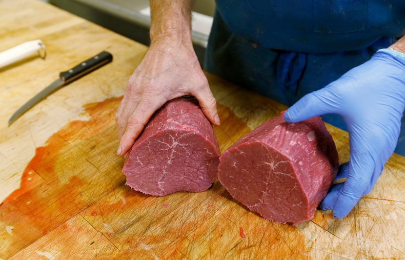 Owner Shawn Knowles cuts meat (eye of round) while he shows how to make jerky at his store...