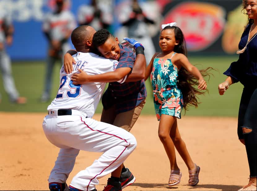 Texas Rangers Adrian Beltre (29) hugs his son Adrian Jr. and daughters Canila and Cassandra...