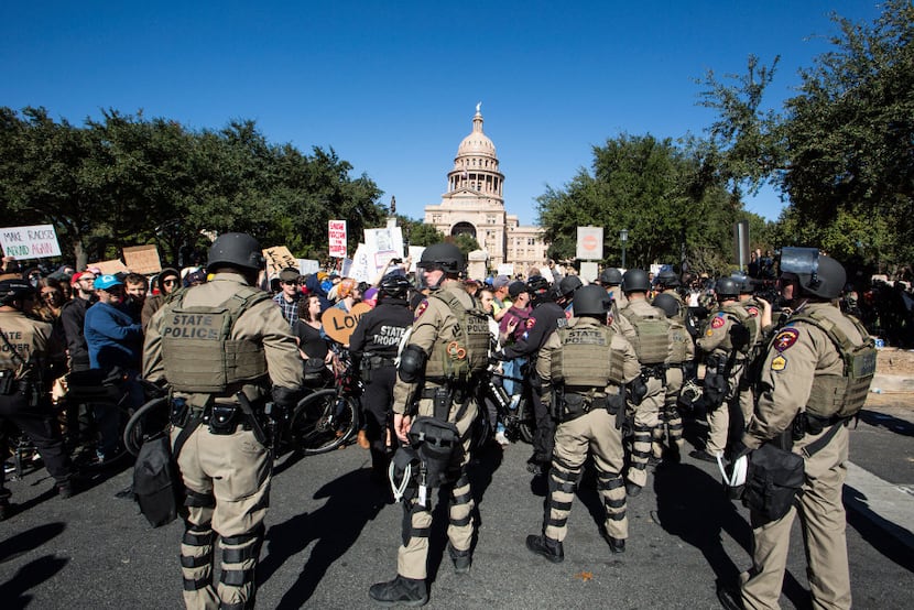 Police in riot gear separate counter-protestors from a White Lives Matter rally outside the...