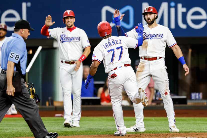 Texas Rangers’ Andy Ibanez (77) is congratulated after hitting a three-run home run during...