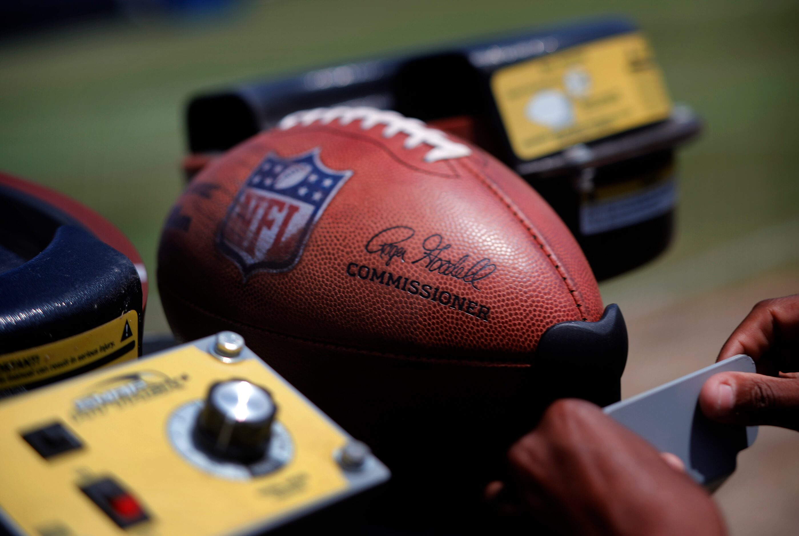 An NFL football is loaded into a throwing machine following a mock game walk thru at...