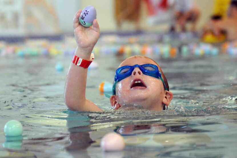 Jack Rourke, 4, comes up from the water with an egg during an underwater Easter egg hunt...
