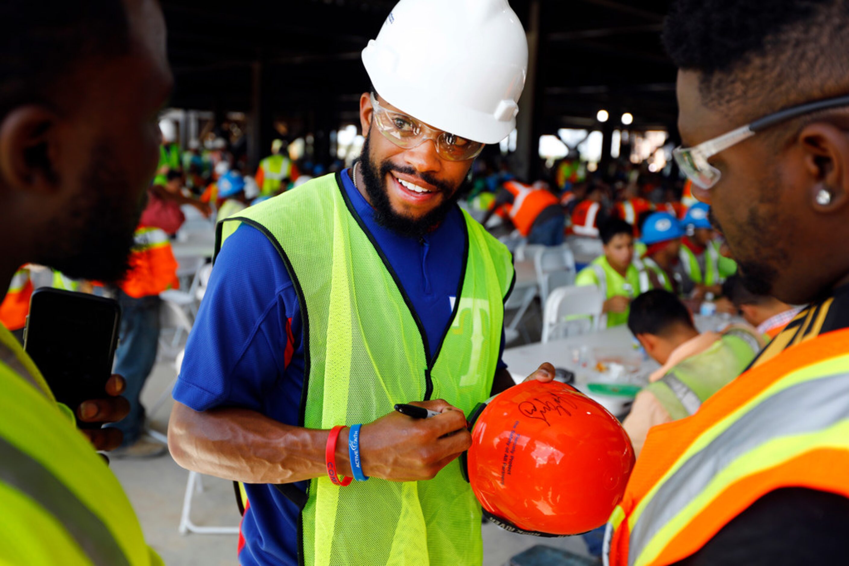 Texas Rangers outfielder Delino DeShields (center) singed autographs for construction...