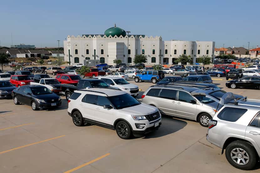 Dozens of cars waited in line during a food bank distribution Thursday at the Islamic Center...