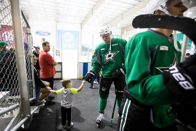 Conor Matejka, 3, of Frisco, gets a fist bump from forward Riley Tufte as he exits the ice...