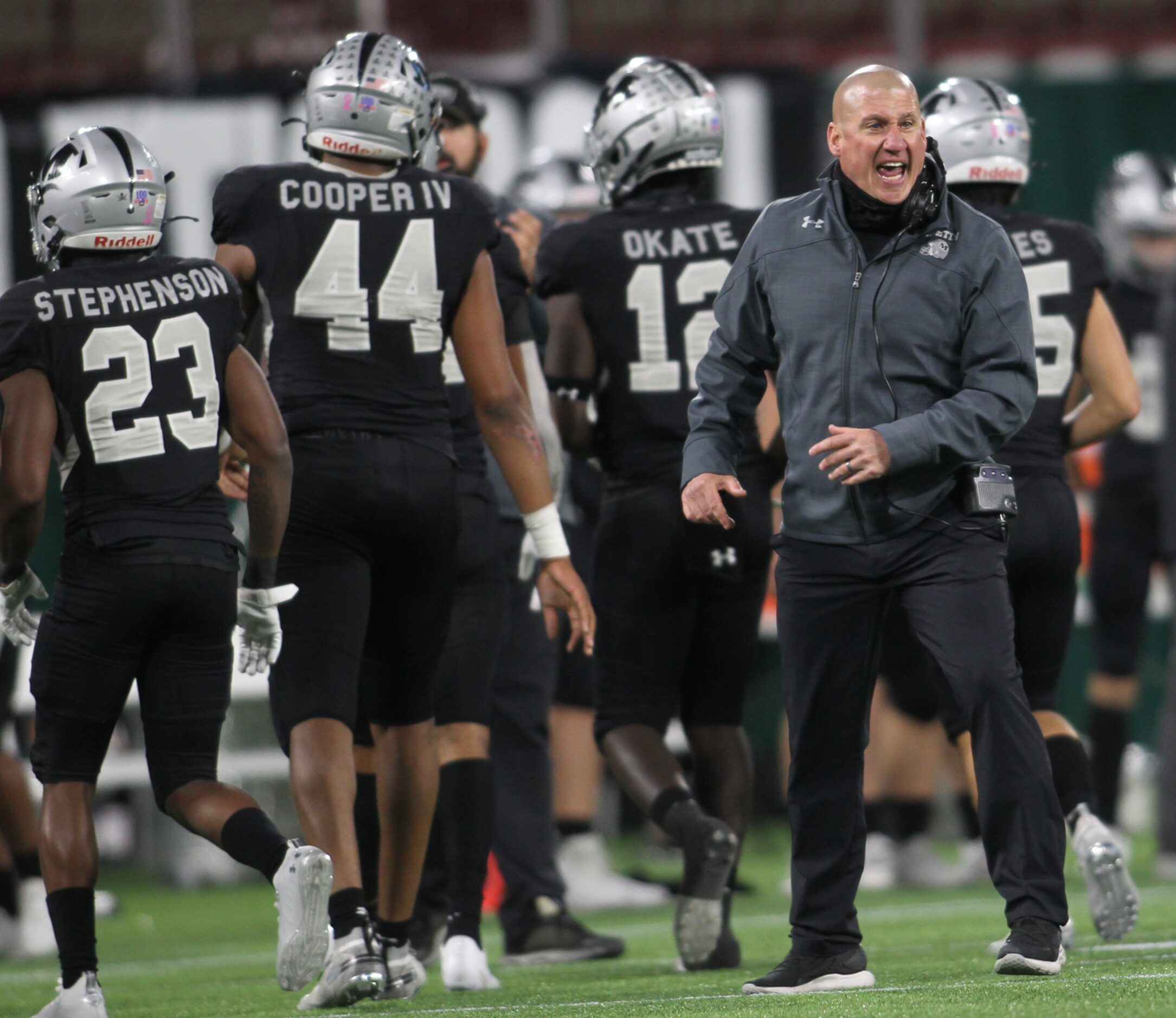 Arlington Martin head coach Bob Wager works to get a message to players on the field during...