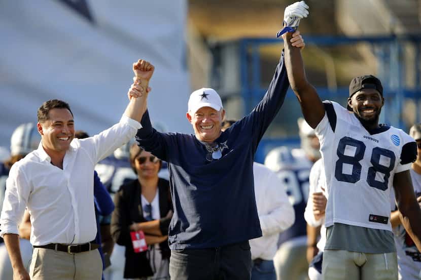 Dallas Cowboys owner Jerry Jones (center) raises the hands of former boxer and now promoter...