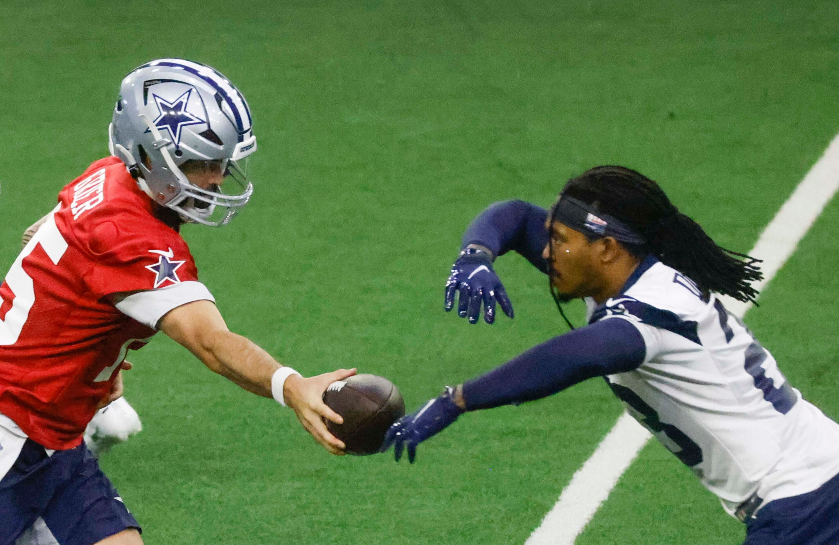 Dallas Cowboys quarterback Will Grier (15) hands off the ball to running back Rico Dowdle...