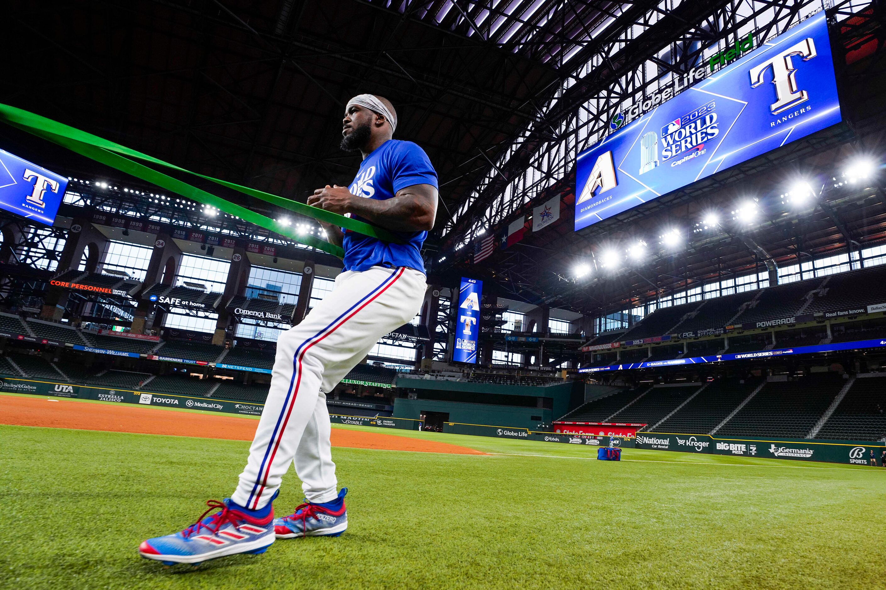 Texas Rangers right fielder Adolis Garcia stretches using a resistance band during a team...