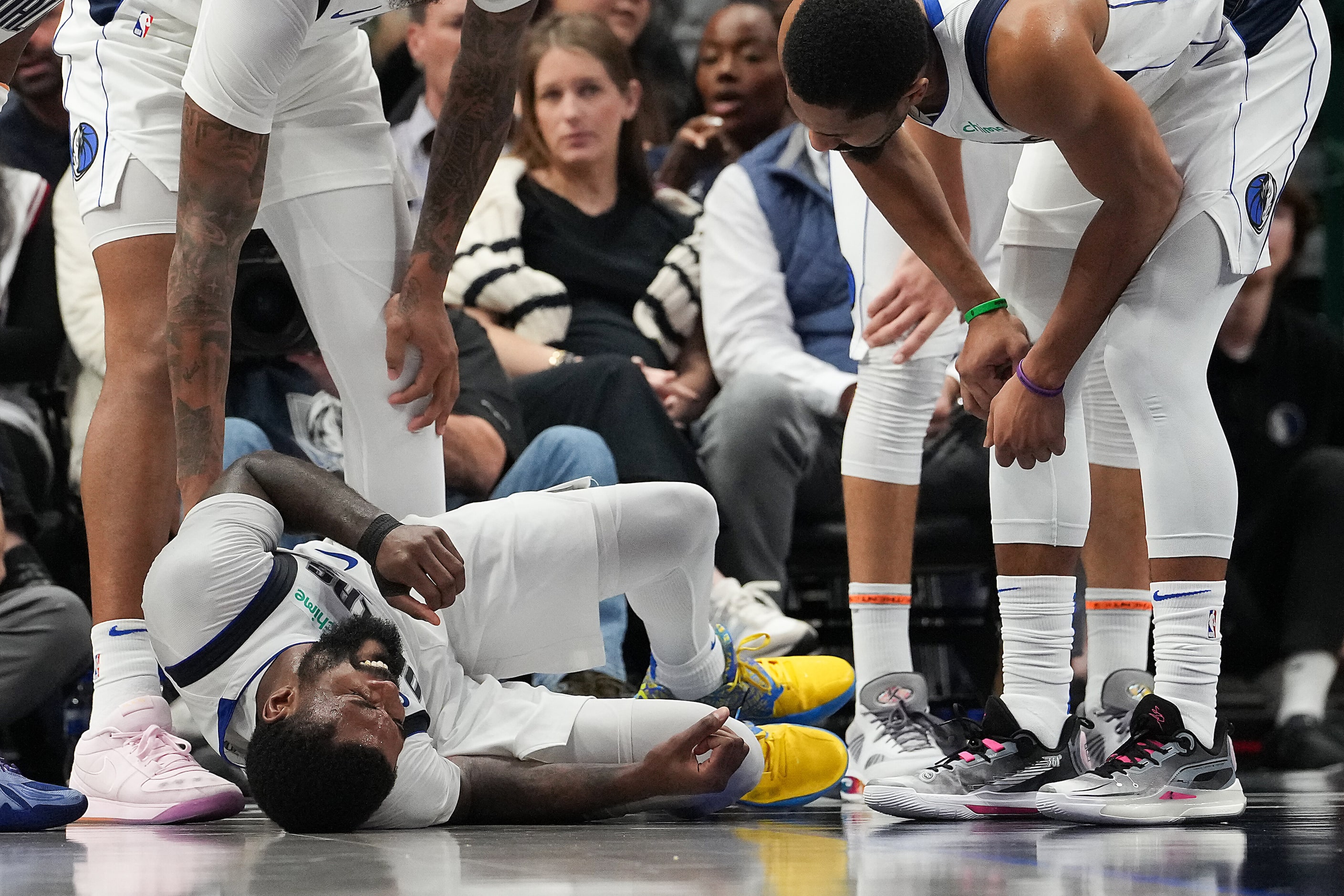 Teammates check on Dallas Mavericks forward Naji Marshall as he is slow to get up from the...