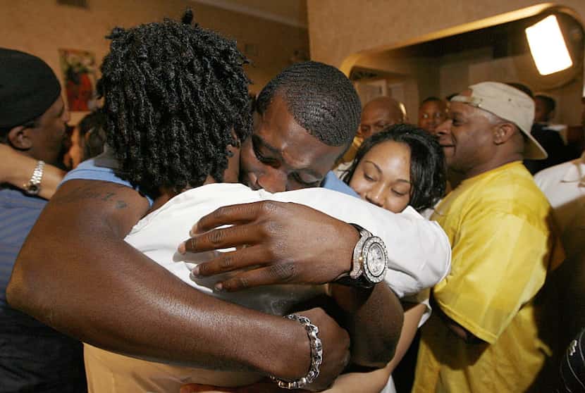 Wide receiver Dez Bryant, center, hugs his mother, Angie Bryant, after being selected as the...