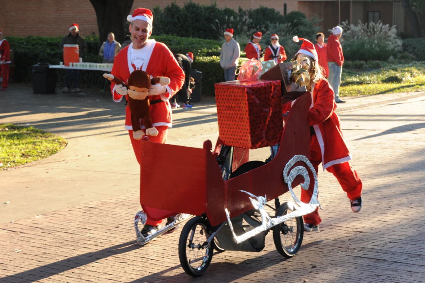 Santa races to the finish line with her sleigh at the Ho Ho Ho Run at Fair Park in Dallas,...