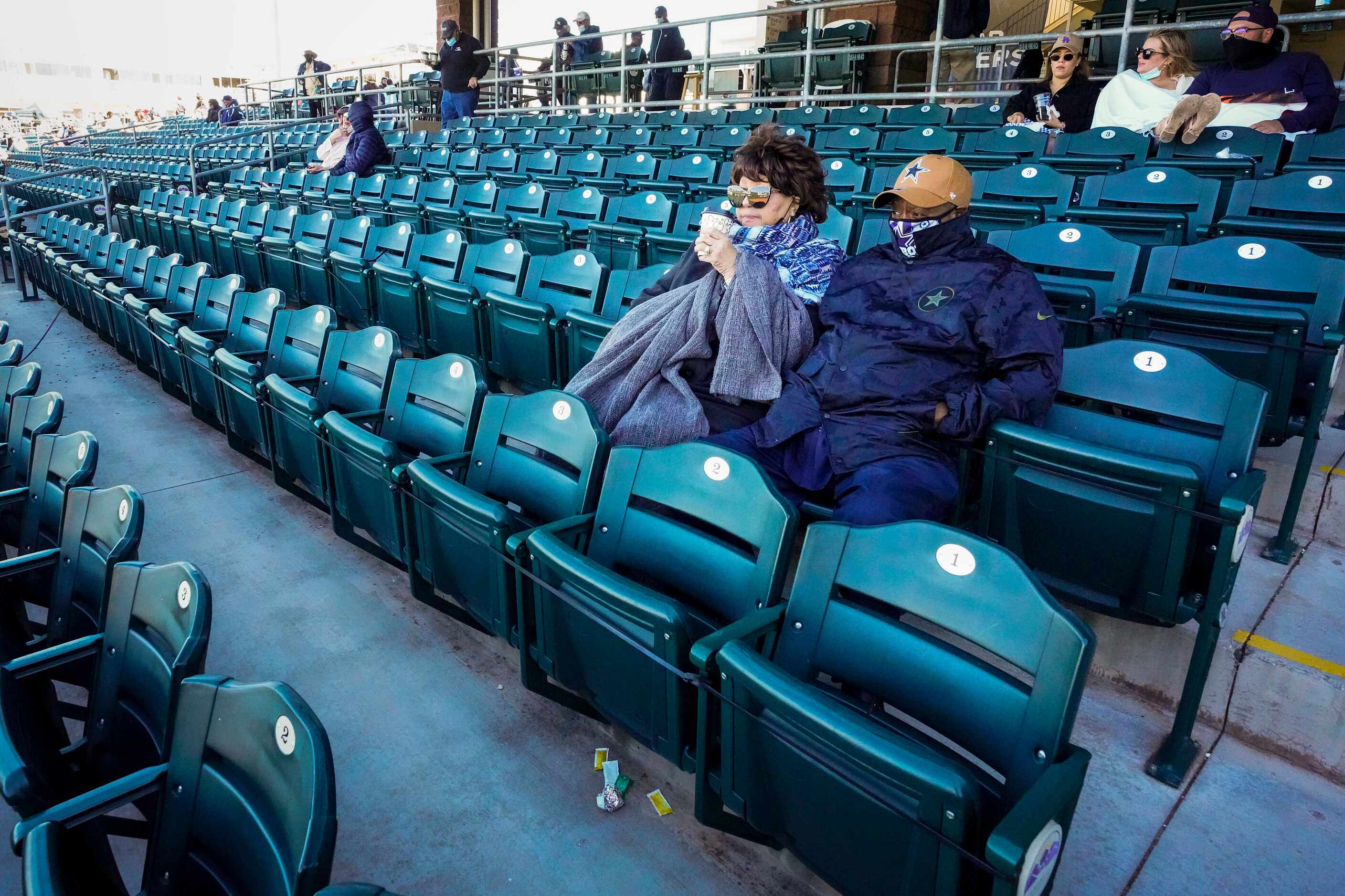 Fans bundle against a chilly afternoon as they watch from socially distant ‘pods’ during a...