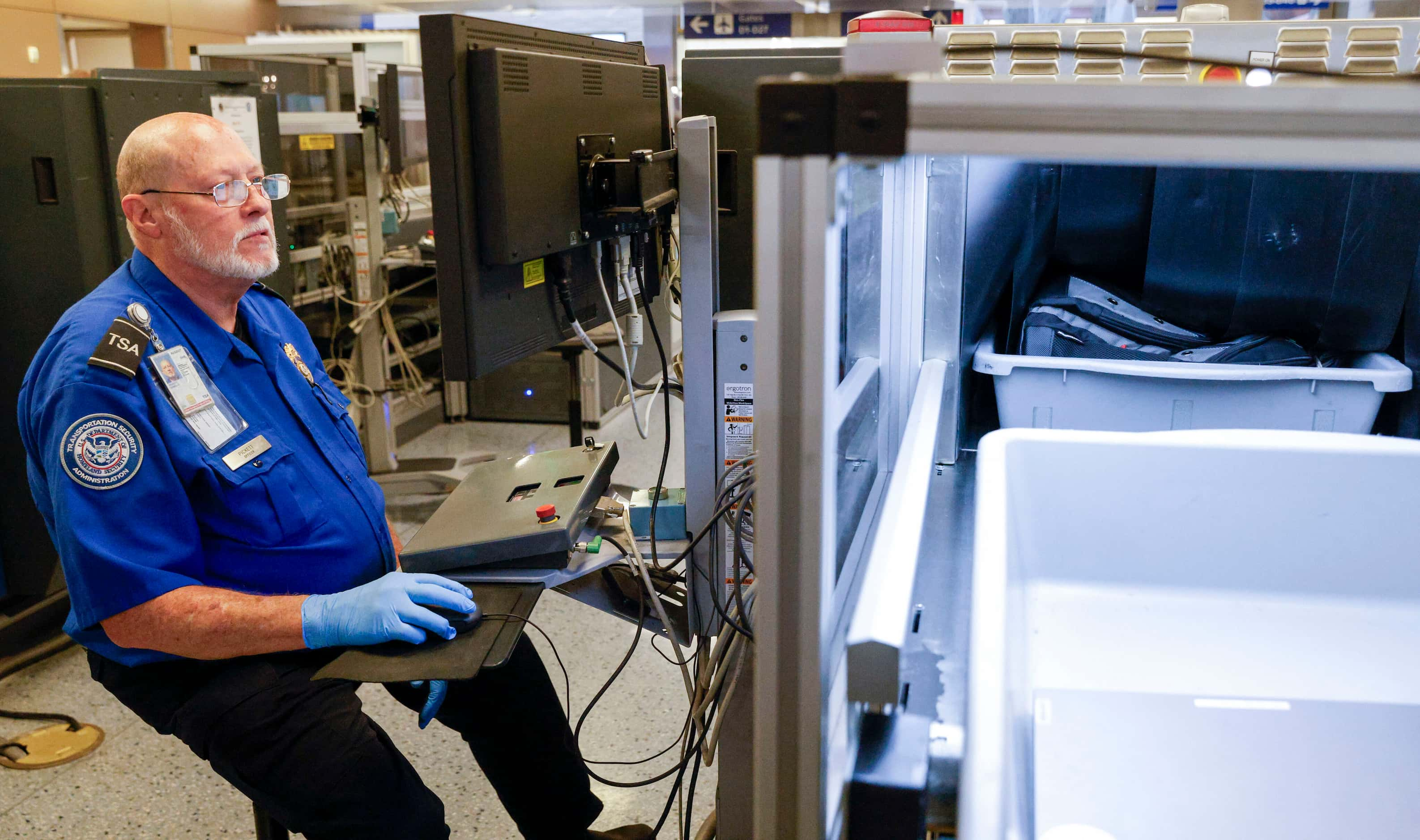 TSA transportation security officer James Pickett checks luggage with an x-ray machine at a...