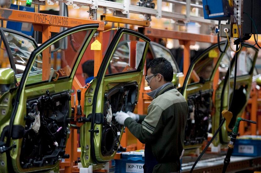 An employee works on the assembly line producing the new Ford Fiesta car, at the Ford Motor...
